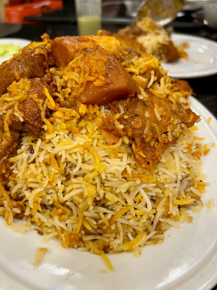 Mutton kacchi biryani served with meat and potatoes piled on top