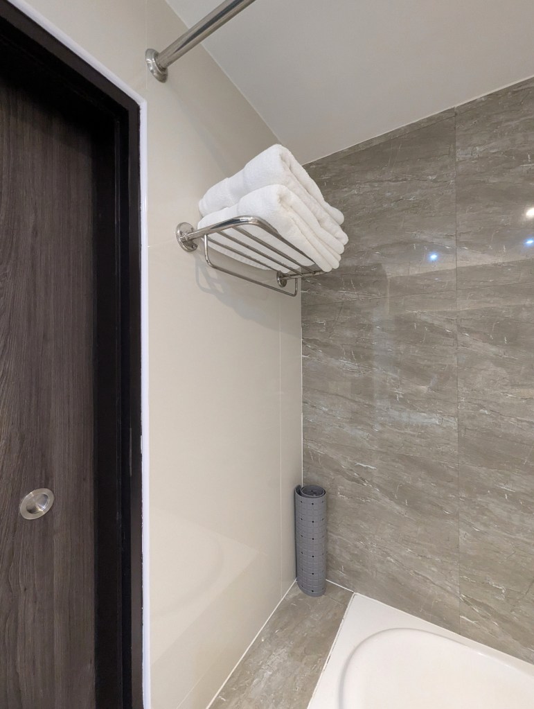 Towels placed in rack in Executive Suite bathroom of Siam Mandarina Hotel in Bangkok.