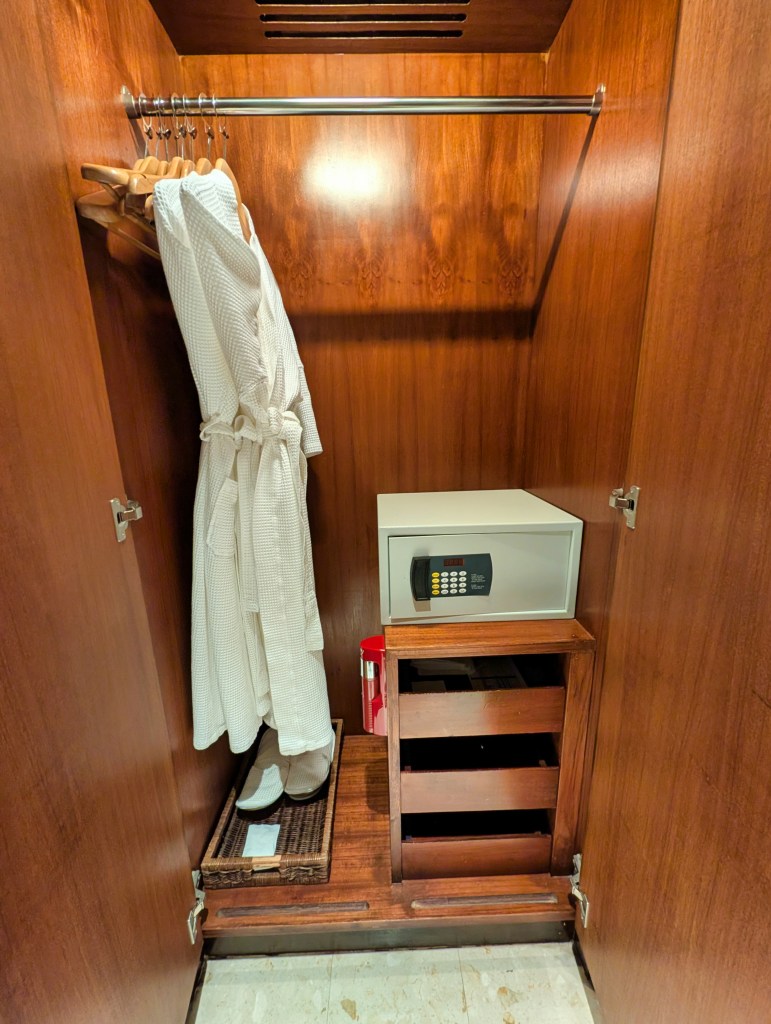 Closet at Hyatt Regency Hotel Suvarnabhumi Airport Bangkok showing robes, slippers, and locker.