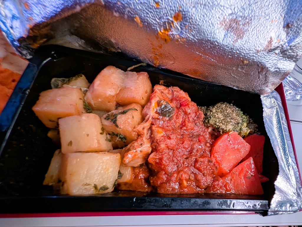 Chicken tomato basil with herbed potato & buttered broccoli and carrot served on Qatar Airways economy class
