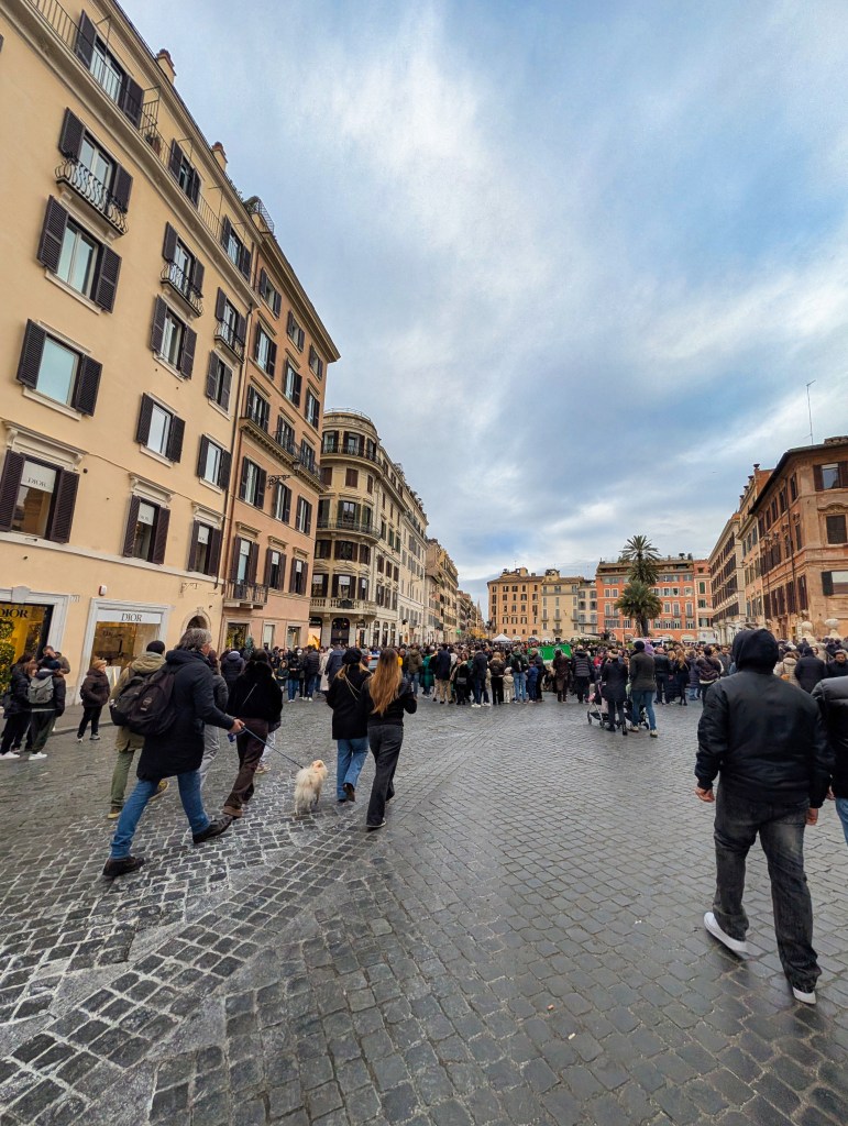 Crowd walking toward the Spanish Steps in Rome, Italy.